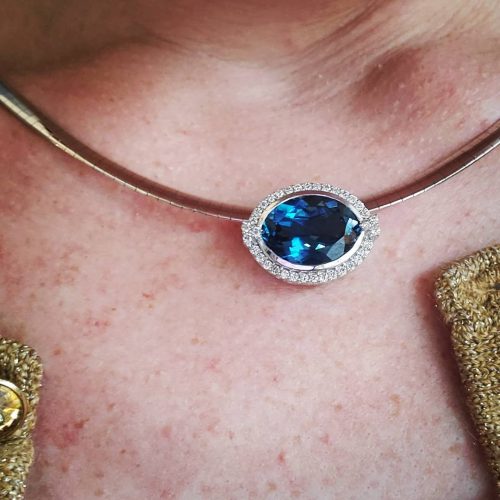 Marquise shape slide pendant with a London blue topaz set inside a 14k white gold diamond halo.