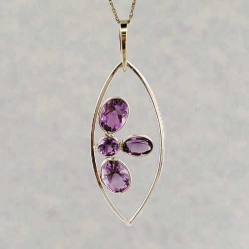Amethyst cluster set in 14k yellow gold in an open leaf shape.