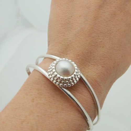 Open sterling silver cuff band with a beaded set white round pearl on top.