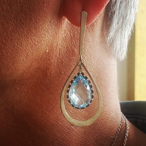 Pear shaped cushion cut sky blue topaz prong set, dangling from 14k yellow gold drop dangles.