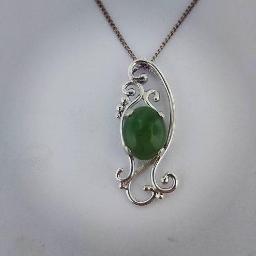Large cabochon jade prong set in an organic sterling silver vine pendant.