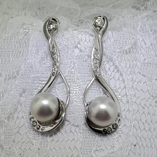 Twisted 14k white gold cradling pearls with diamond accents.