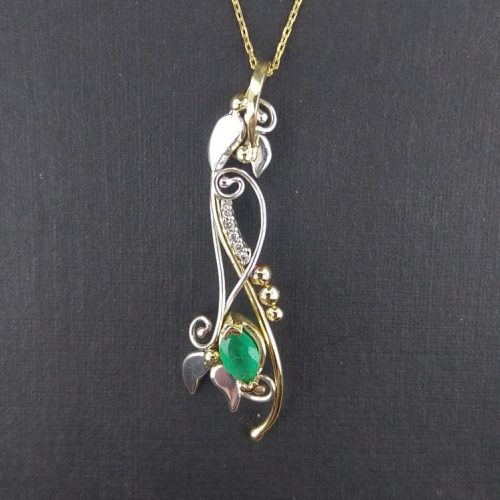 Leaf and vines crafted out of 14k white and yellow gold with a marquise shape emerald and diamond accents.