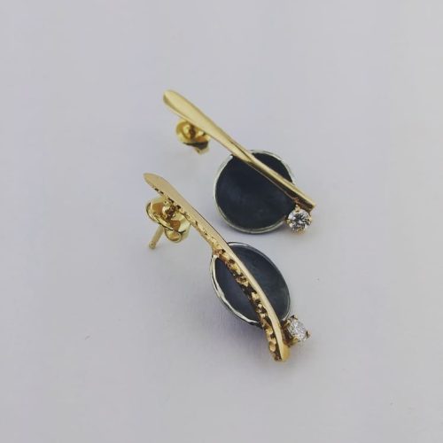 Blackened sterling silver disks on 14k yellow gold branches and round diamond accents.
