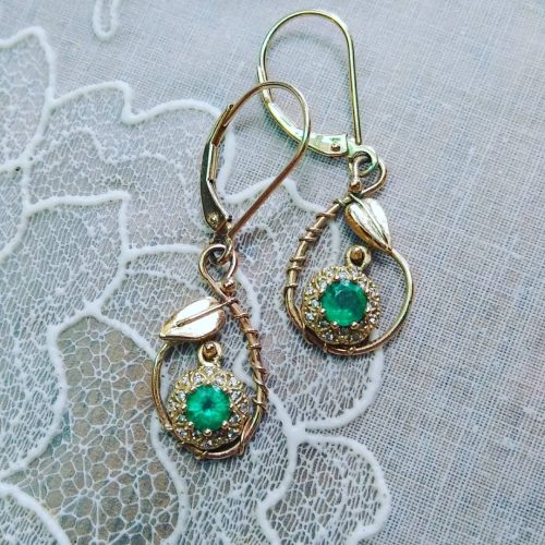 Vintage inspired bright green emeralds set in 14k yellow gold dangles in pear shaped leaf and vine frames.