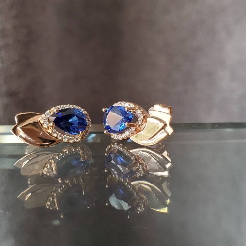 Pear shaped blue sapphires with a diamond halo and 14k yellow gold leaf accents.
