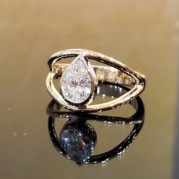 Pear shaped diamond bezel set in 14k yellow gold on a open band, engagement ring, alternative style. Item 1008