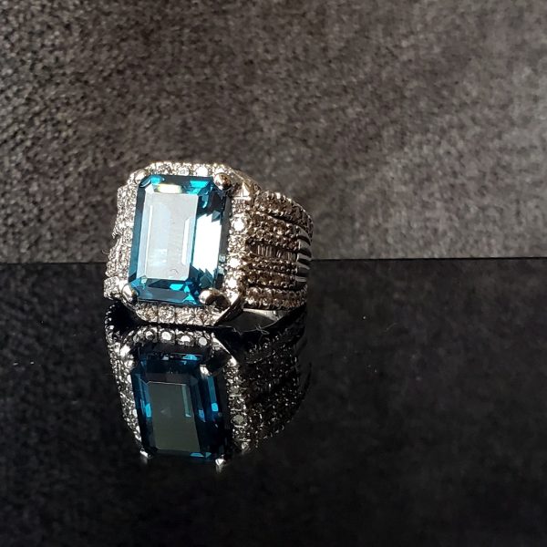 Emerald cut sapphire, set in a diamond halo with a fully accented diamond band, in 14k white gold.
