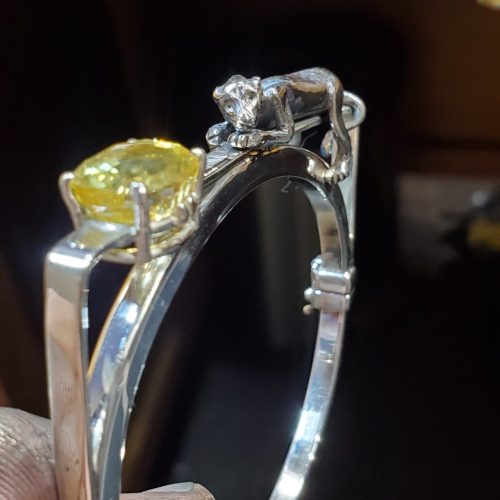 Sterling silver hinge bangle with square top and prong set stones.