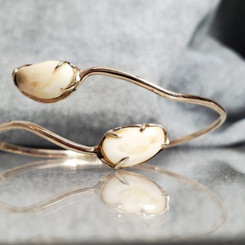 14k yellow gold open bangle with prong set elk teeth on either end.