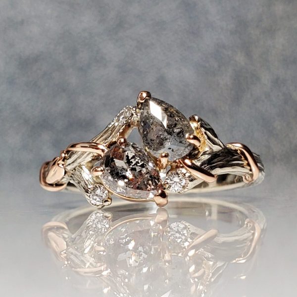 Two pear shaped salt and pepper diamonds, set on a 14k white gold branch band with 14k rose gold leaf details, accent diamonds throughout, alternative engagement ring, nature inspired.
