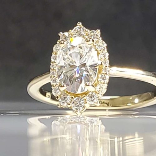 Tapered oval diamond halo engagement ring on a delicate band set in 14k yellow gold. Made in Morgantown, West Virginia USA