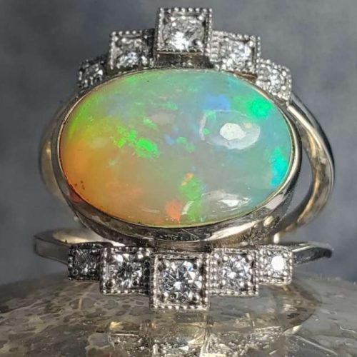 Art deco style right hand ring with a bezel set Ethiopian opal and diamond accents and milgrain detailing. Made in Morgantown, West Virginia USA