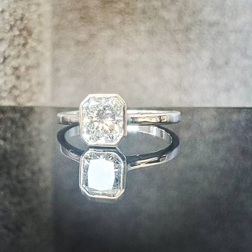 A large prong set emerald cabochon with bezel set diamonds on a 14k white gold ring. Made by Katherine Spencer in Morgantown, West Virginia USA