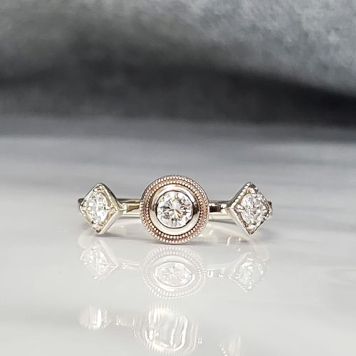 A simple halo and accented band of 14k white gold with a peak-a-boo diamond trio under the oval blue diamond center.
