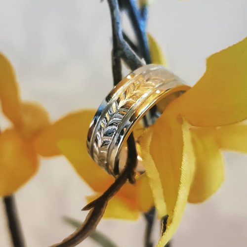 One Ladies and one men's wedding band in 14k yellow, overlapped to make one band, accented with diamonds for each year of marriage.