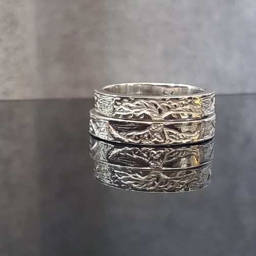 Two elk teeth bezel set in sterling silver with hand crafted leaf bezels on a 14k yellow gold beaded band.