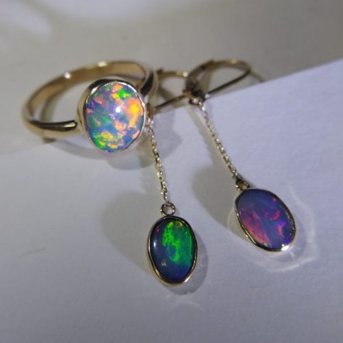 Emerald and blue topaz bezel set stacking rings set in 14k yellow gold with diamond accented bands.