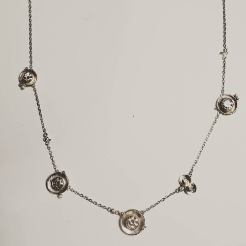 This 14k yellow gold slide pendant cradles a large marquise and round diamond in the center of its forged marquise shape, with three flush set round diamond accents.