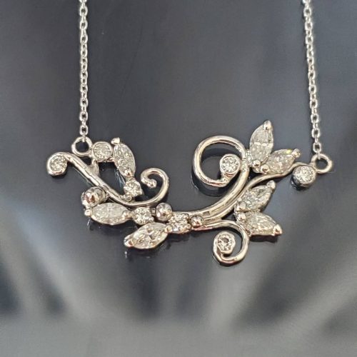 14k white gold crafted vines, with prong set marquise diamond leaves and bezel set round diamond accents create the center of this necklace.