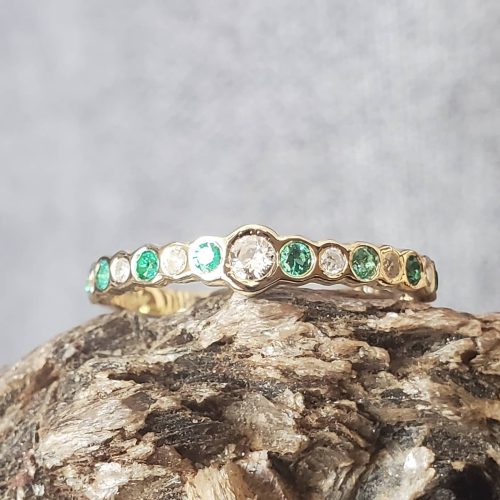 A large London Blue Topaz is cradled by a bed of diamonds set in 14k white gold placed on a delicate 14k yellow gold band