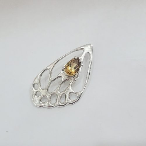 Sterling silver cut out butterfly wing with a pear shaped yellow sapphire, crafted into a slide pendant.