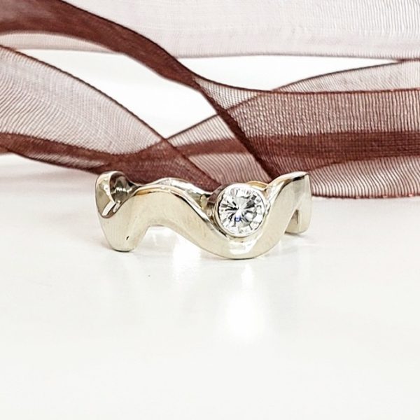 This ring is inspired by the rolling hills of West Virgnia crafted of 14k white gold, and cradles a bezel set bright white diamond, alternative engagement ring. Item 8240