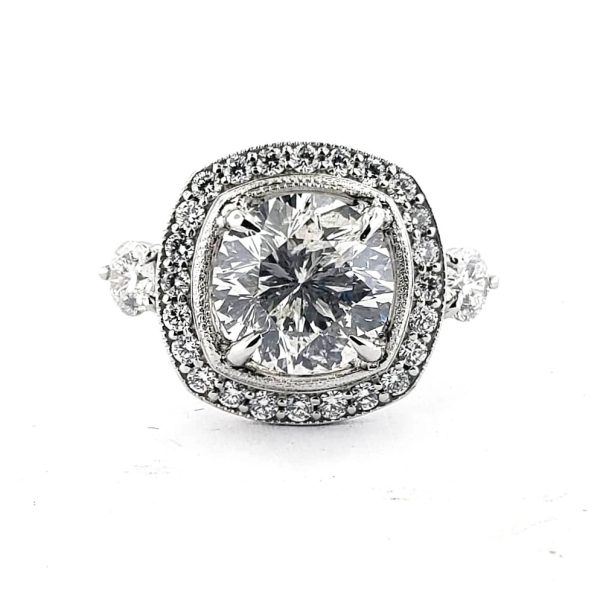 Round white diamond set in a square diamond halo with a diamond accented band in 14k white gold.