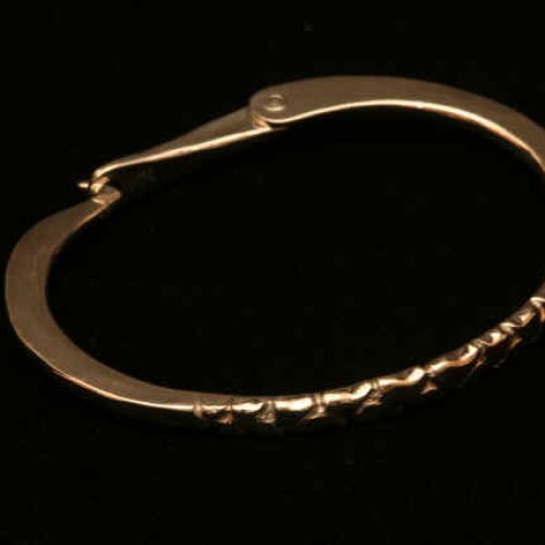 14k yellow gold hammered flat bracelet with hand fabricated hinge closure and carved detail.