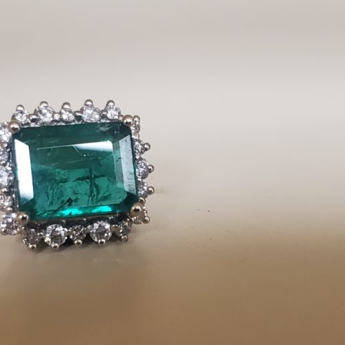 Emerald cut bright green emerald on a vintage inspired diamond halo, crafted to be a slide pendant.