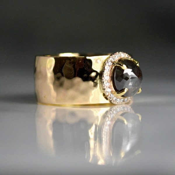 Rose cut black diamond with a white diamond halo, on a thick 14k yellow gold hammer textured band.