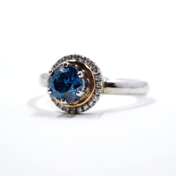 Blue diamond set with a 14k yellow gold white diamond halo, on a 14k white gold band.