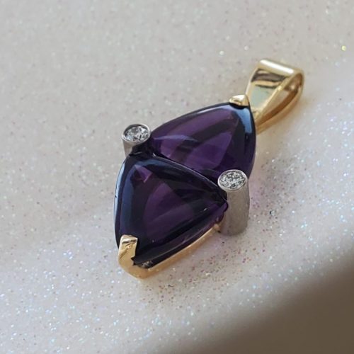 Mirrored trillion deep purple amethyst prong set in 14k yellow gold.